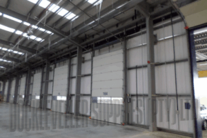Insulated sectional industrial door with torsion spring balance, track options and integrated safety systems for commercial applications in South Africa.